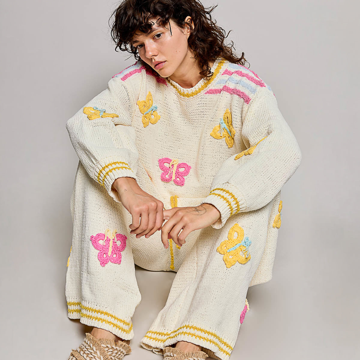 POL Clothing cream multi 3D butterfly chenille sweater top on model, cropped seated pose showing balloon sleeves and appliqué detail
