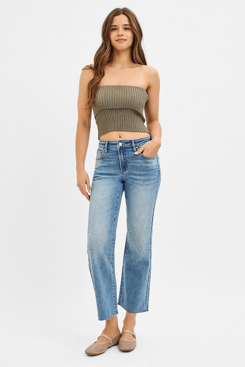 Woman wearing a strapless top and jeans on a white background