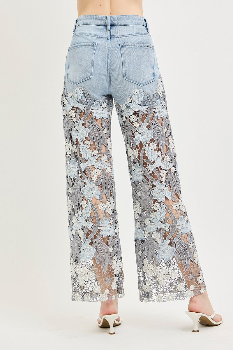 Floral lace pants over light blue jeans on a white background 