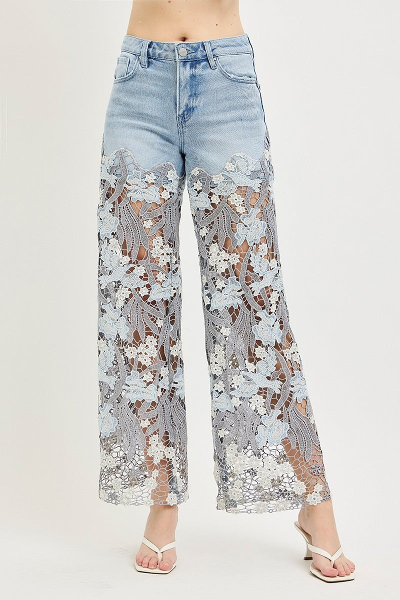 Light blue jeans with floral lace detailing on a white background