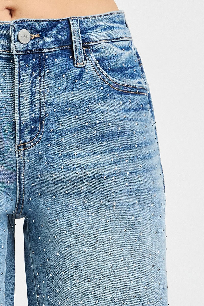 Close-up of blue jeans with rhinestone embellishments on a white background