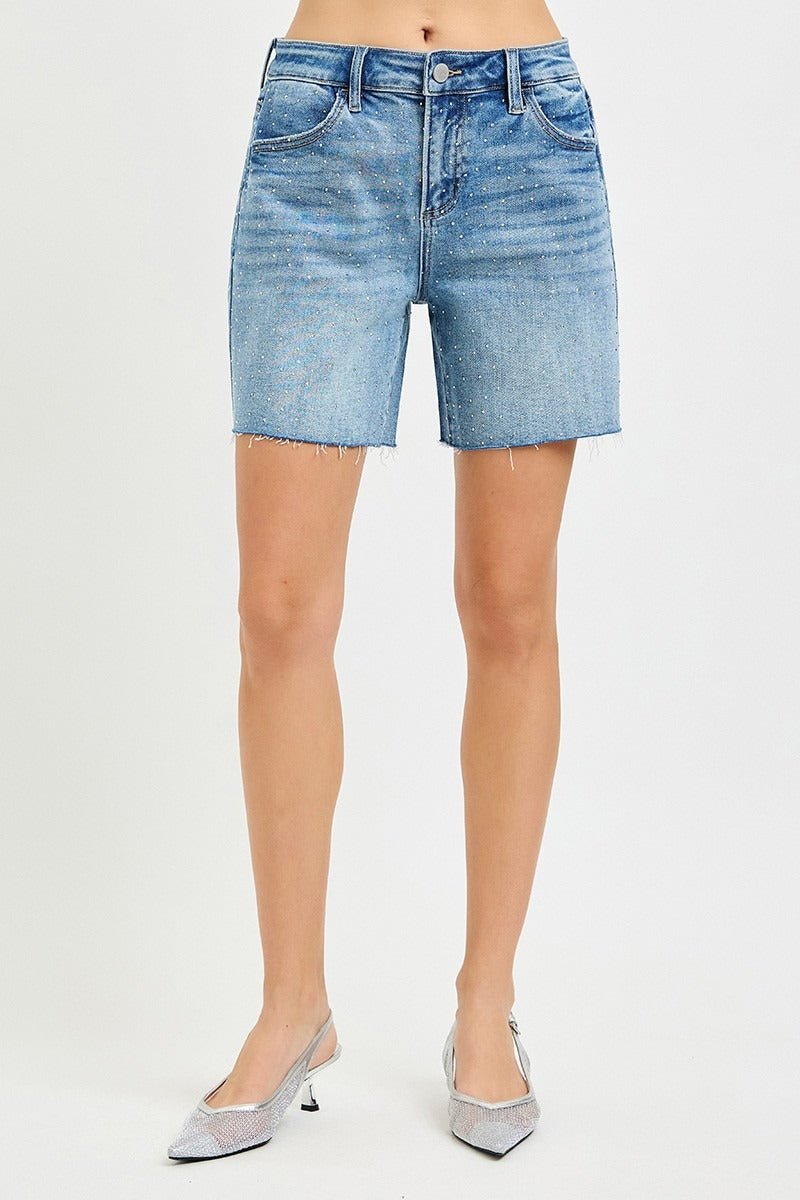 Blue denim shorts worn by a person on a white background