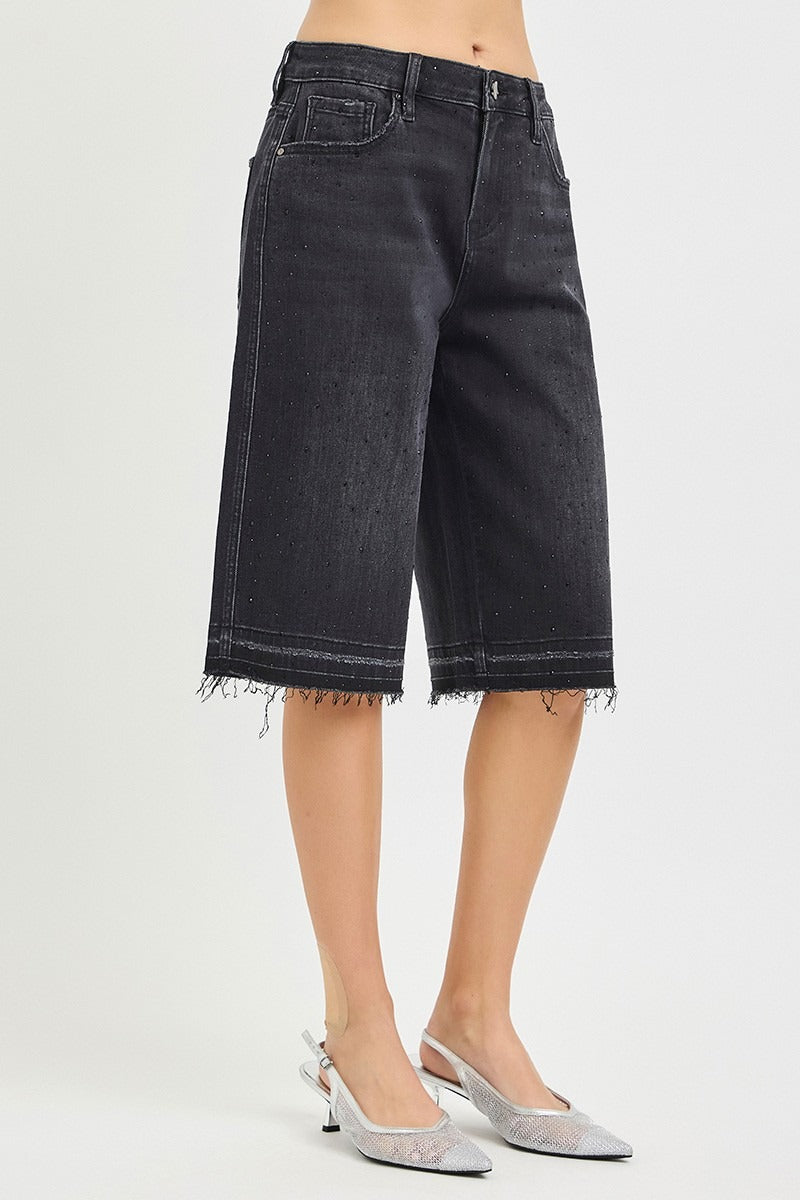 Black denim shorts worn by a person on a white background