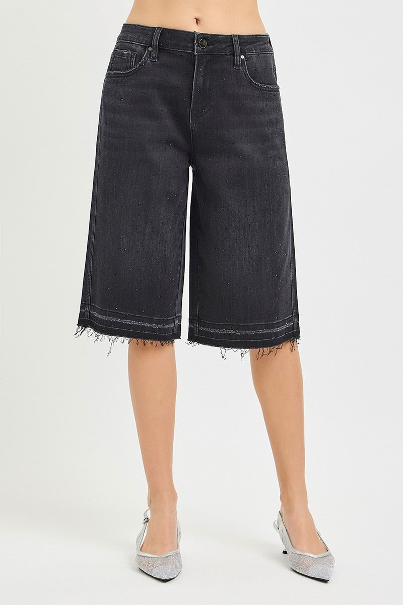 Black denim shorts worn by a person on a white background