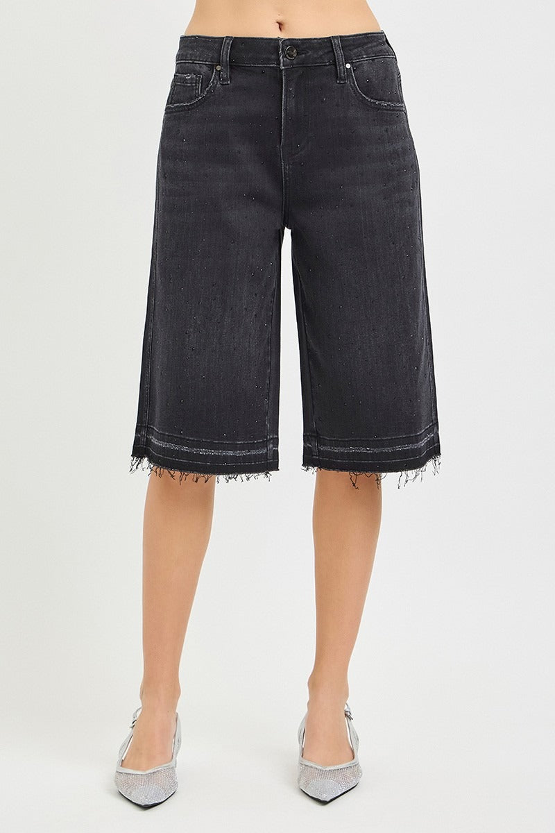 Black denim shorts worn by a person on a white background