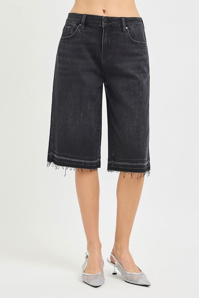 Black denim shorts worn by a person on a white background