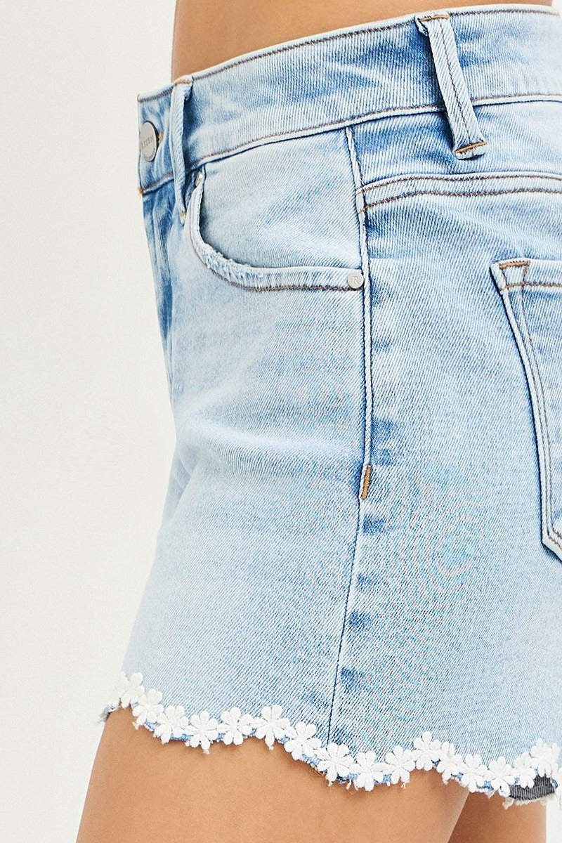 Light blue denim skirt with floral hem on a white background