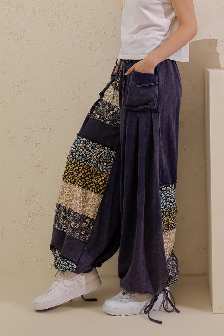 Sage + Fig navy floral patchwork wide-leg pants modeled in a relaxed stance