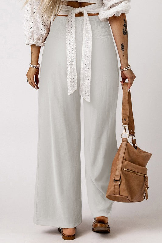 a woman wearing a white top and white pants