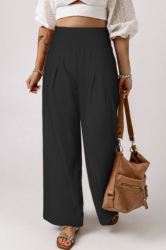 a woman wearing a white top and black pants