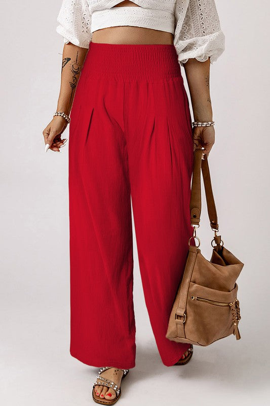 a woman in a white top and red pants