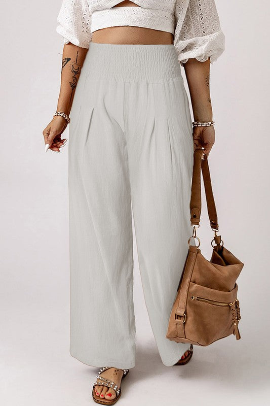 a woman holding a purse and wearing a white top