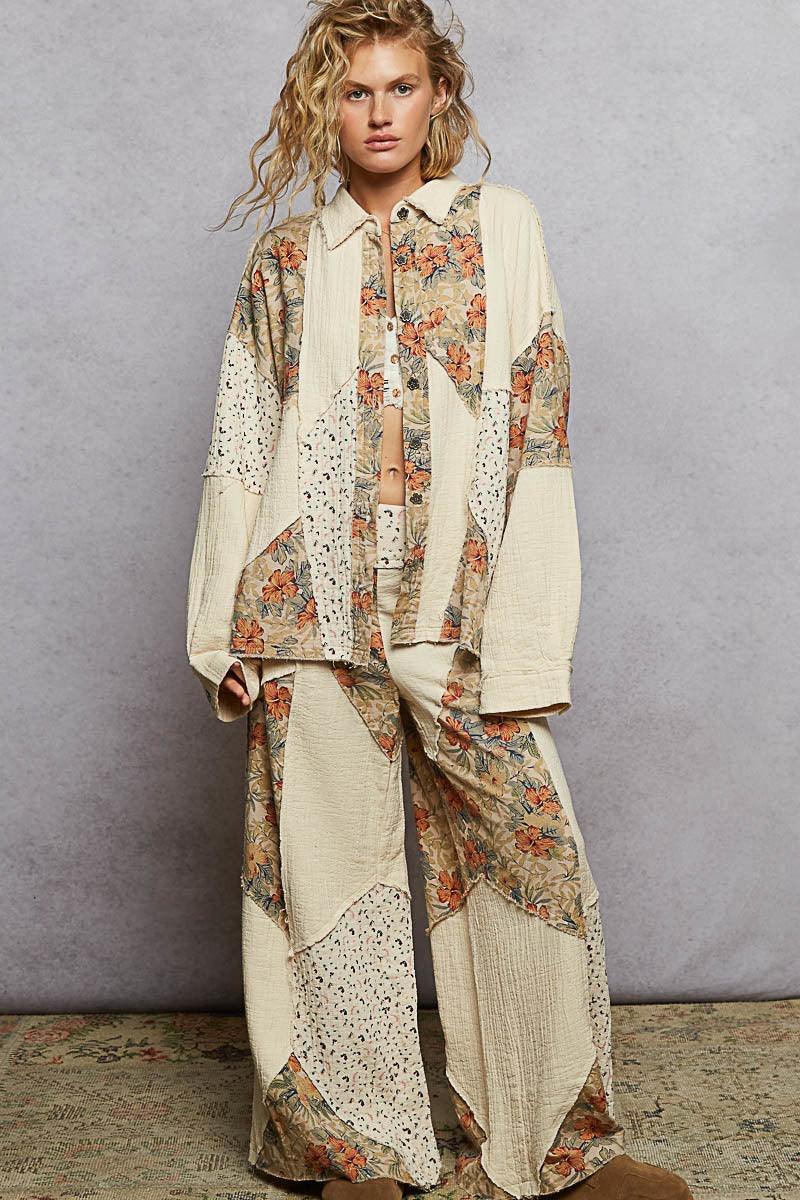 Woman wearing a patchwork outfit with floral patterns against a plain background