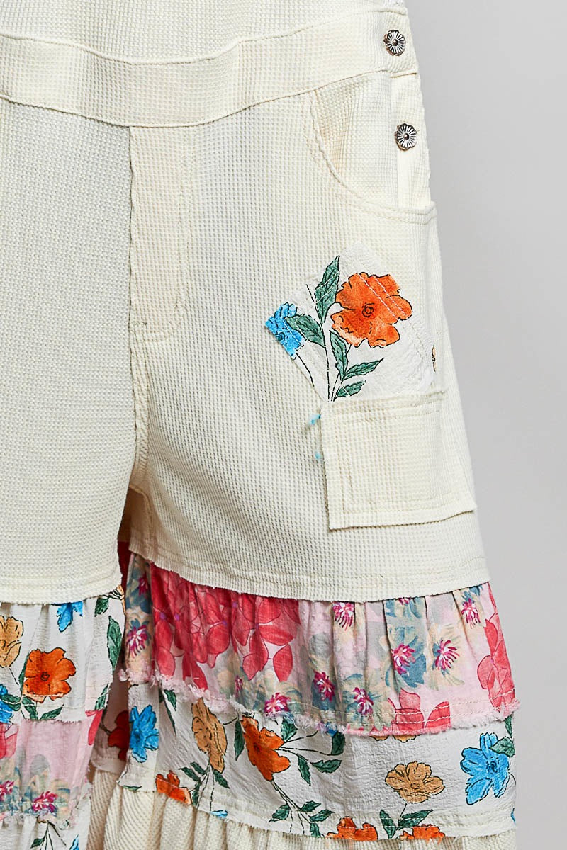 Skirt with floral embroidery and multicolored layers on a plain background