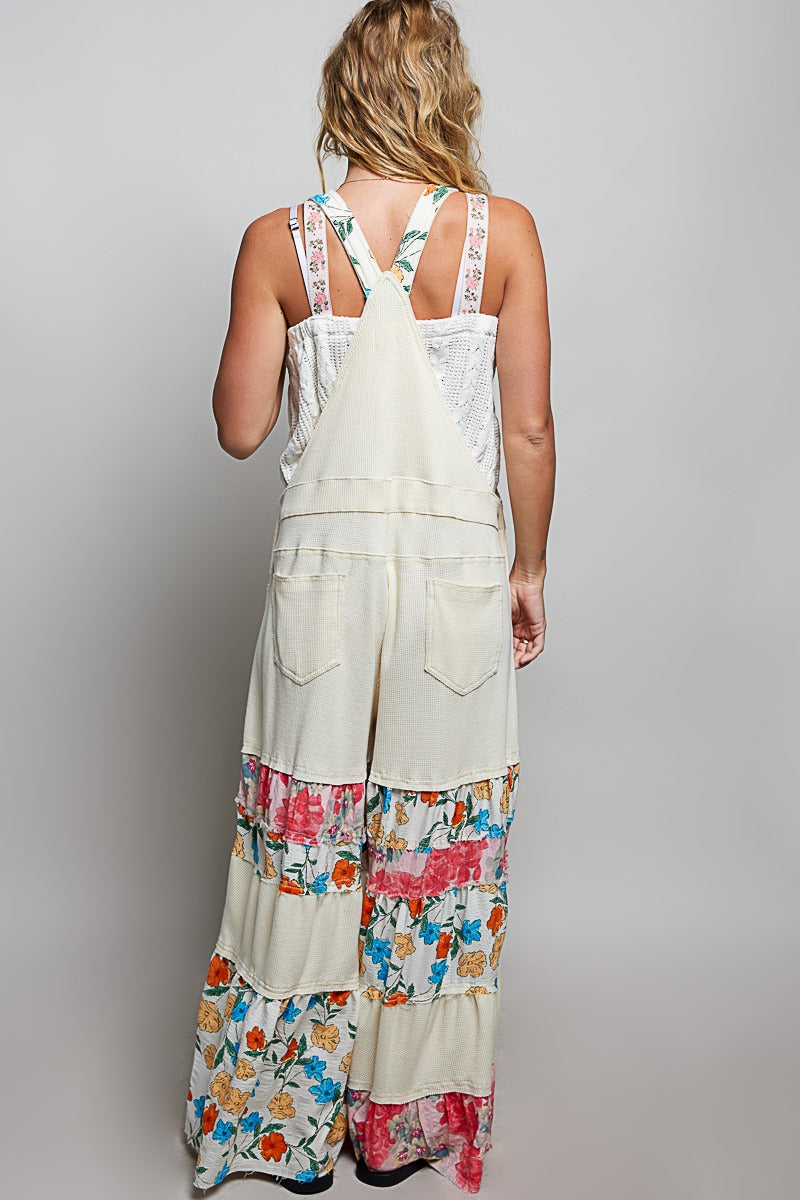 Woman wearing a long, floral-patterned dress with a plain background