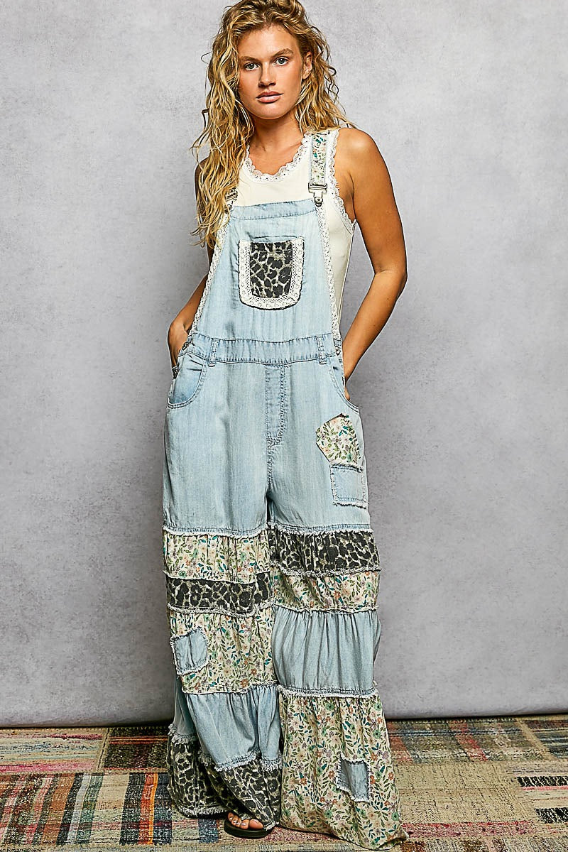 Woman wearing a patchwork denim overalls with a plain background