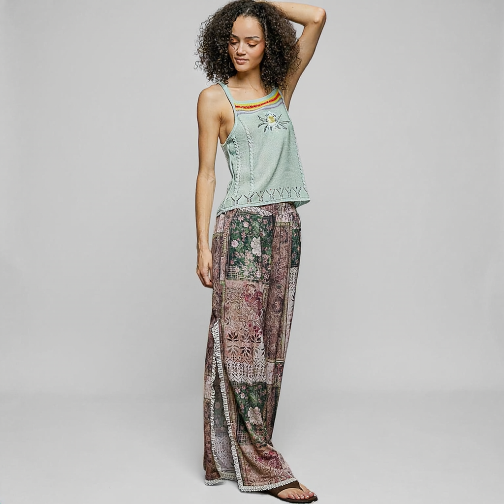POL Clothing Rose Multi patchwork wide-leg pants on a model, showing floral print and lace-trimmed side openings.

