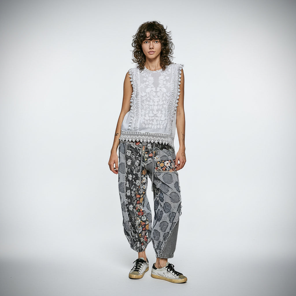 POL Clothing women wearing a sleeveless top with lace details and patterned pants on a plain background