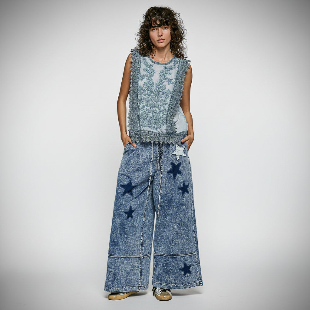 POL Clothing Person wearing a sleeveless blue top and wide-leg jeans with star patterns on a gray background