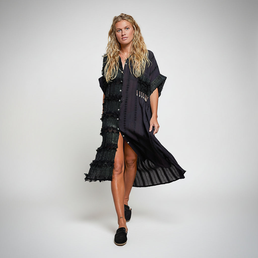 Woman wearing a black dress with ruffled details on a white background