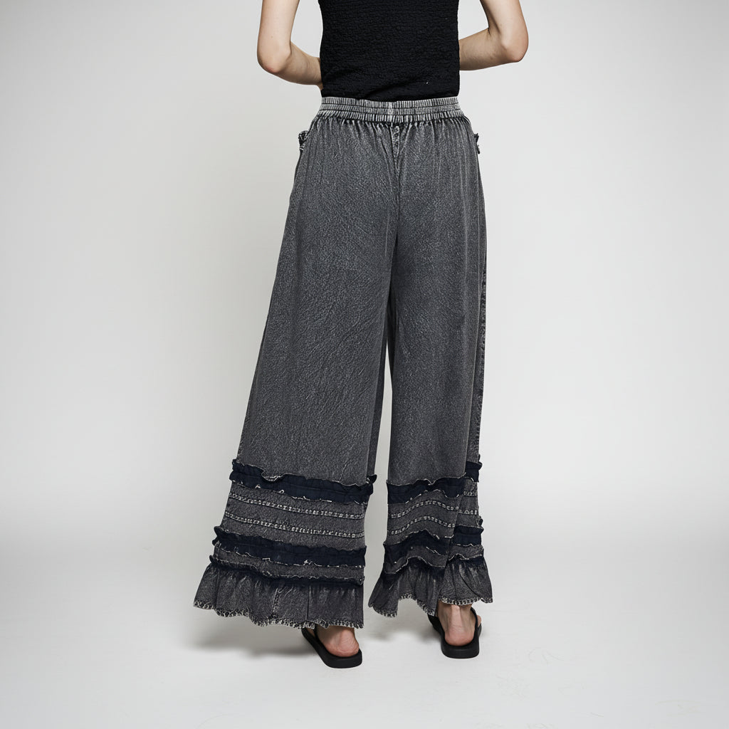 Women's charcoal wide-leg pants with ruffle hem detail and patch pockets, washed finish close-up view