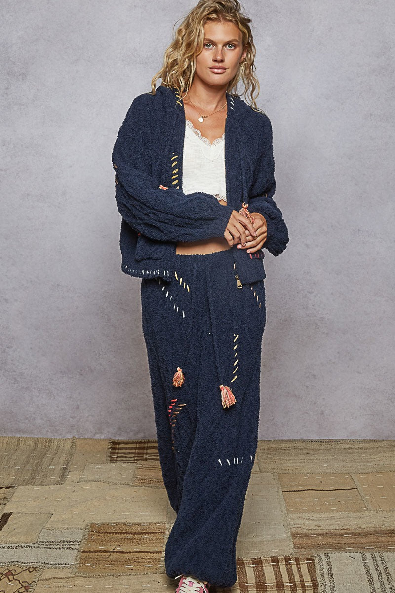 Woman wearing a navy blue outfit with a white background