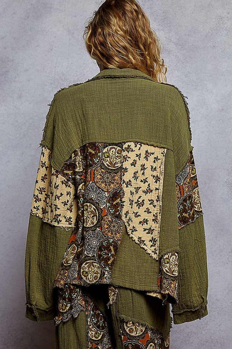 Person wearing a green patchwork jacket against a gray background