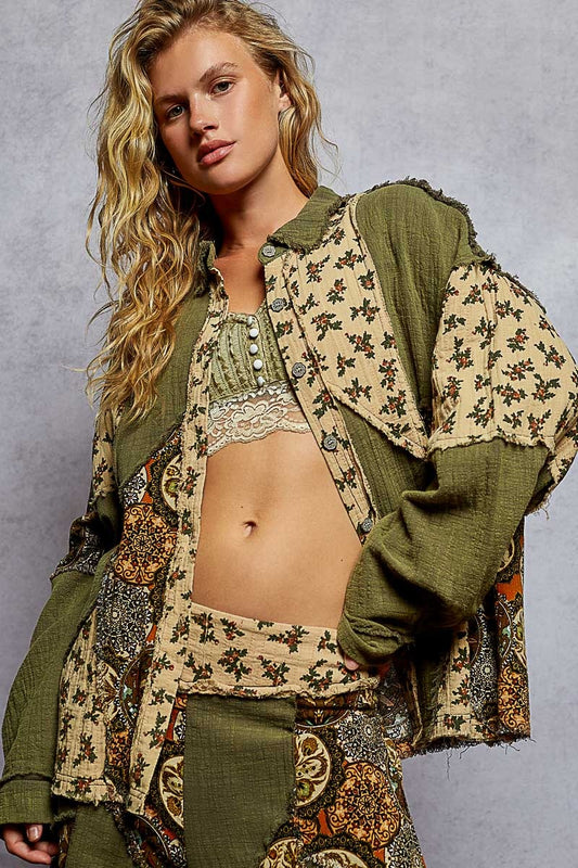 Woman wearing a patterned outfit with a green jacket against a gray background