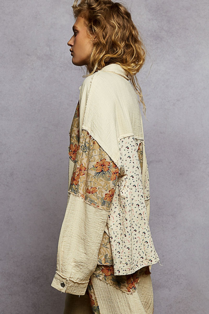 Woman wearing a floral and patterned kimono-style garment against a gray background