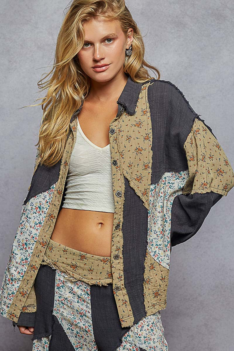 Woman wearing a patchwork jacket over a crop top and pants on a gray background