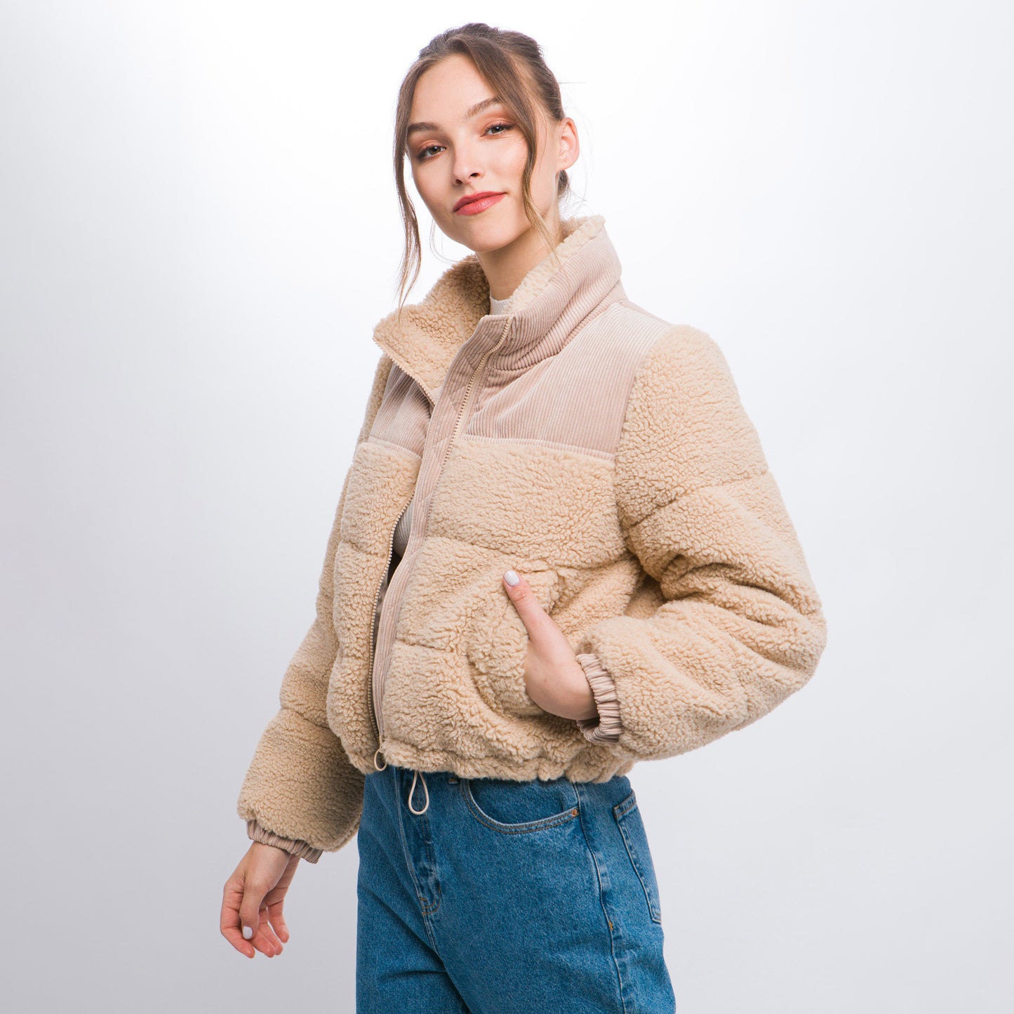 a woman in a jacket and jeans posing for a picture