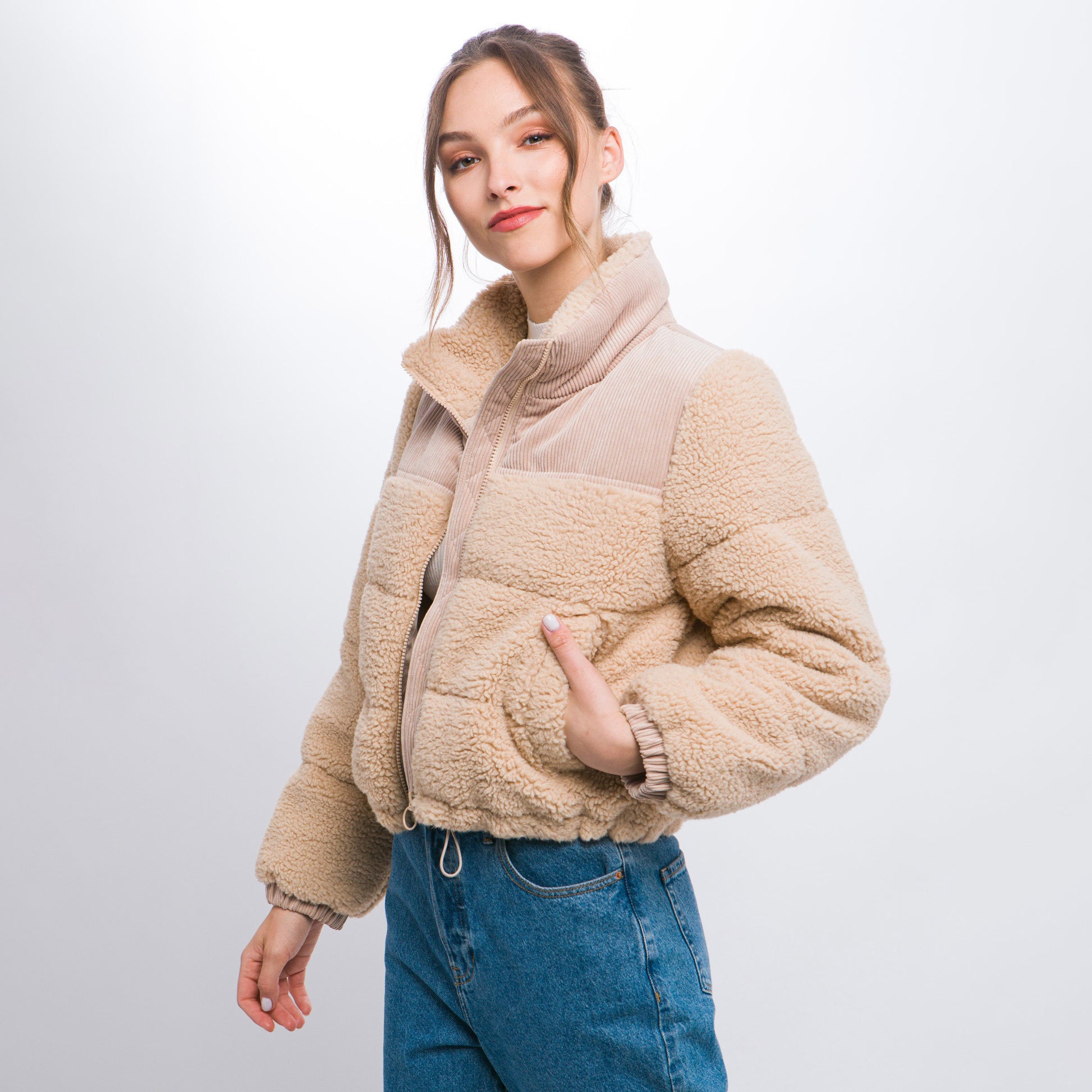 a woman in a jacket and jeans posing for a picture