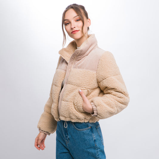 a woman in a jacket and jeans posing for a picture