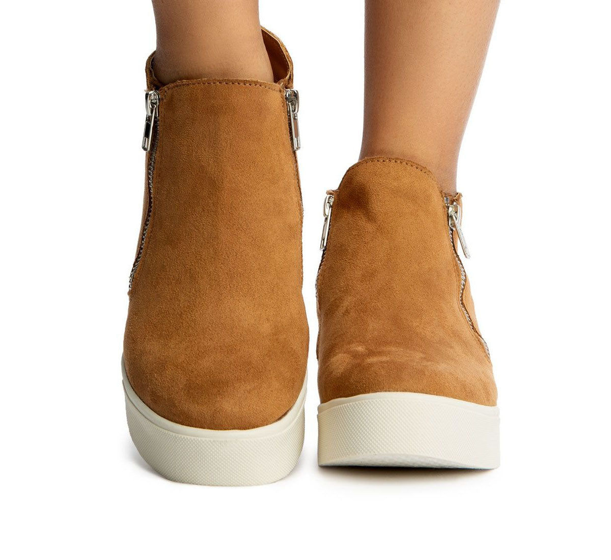 Brown suede ankle boots with white soles on a white background