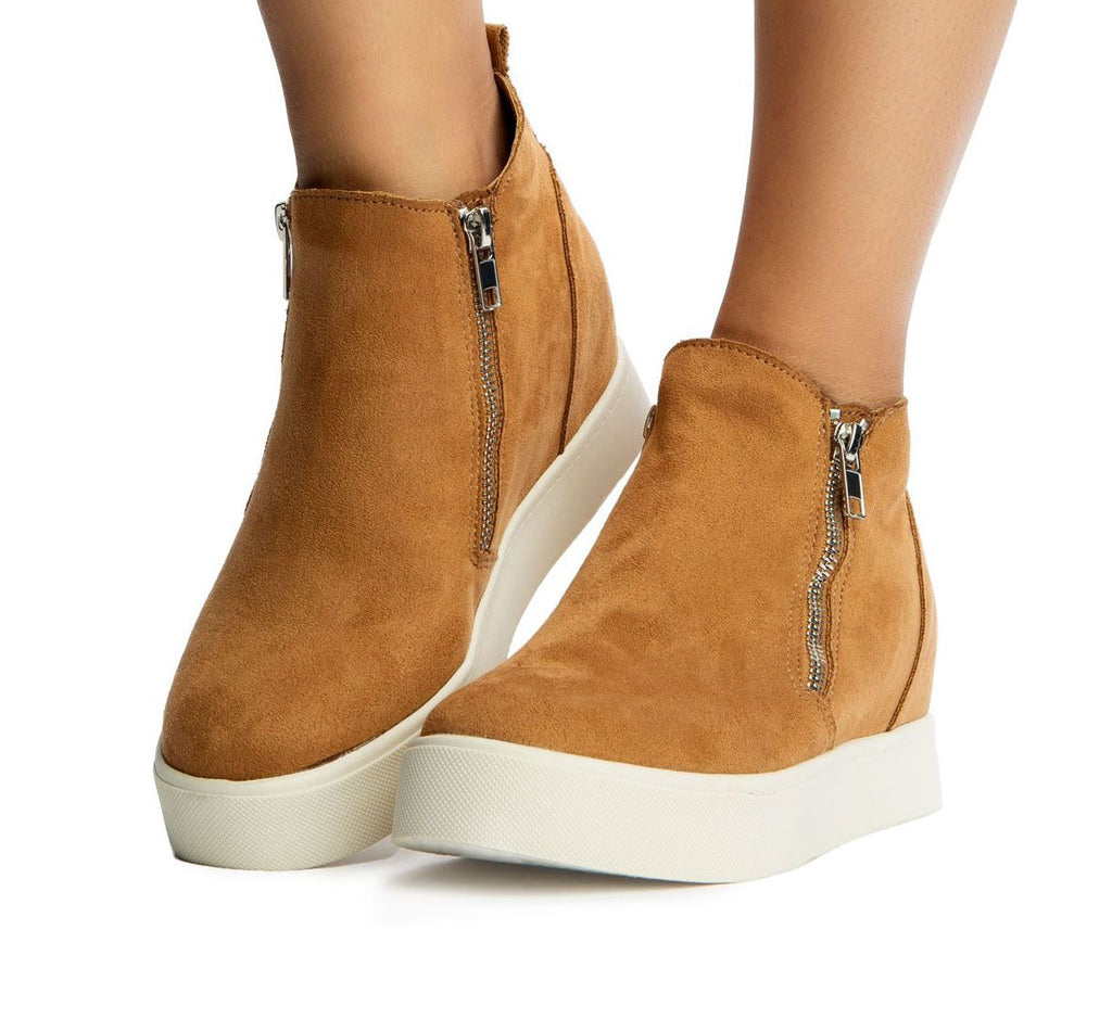 Tan high-top sneakers with white soles on a white background