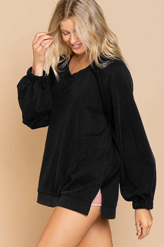 a woman wearing a black sweatshirt and pink shorts