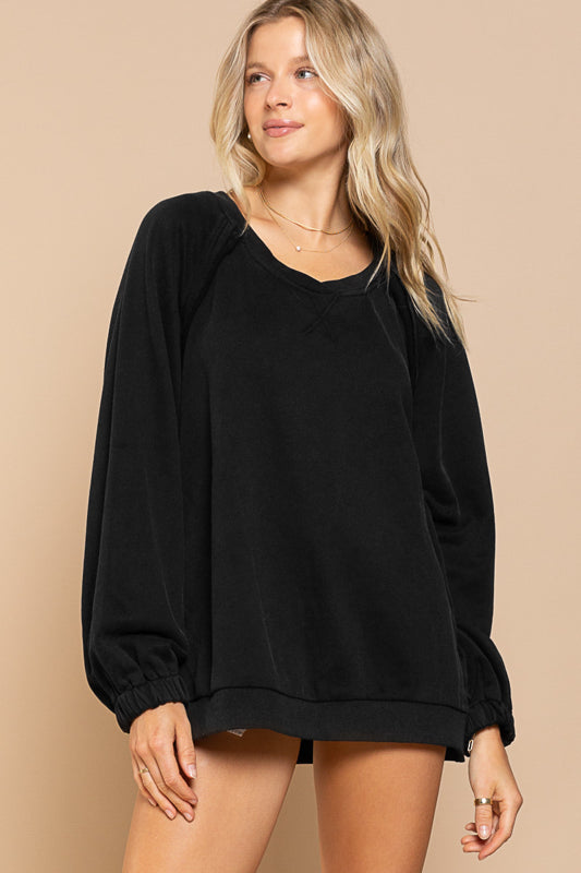 a woman wearing a black sweatshirt and shorts
