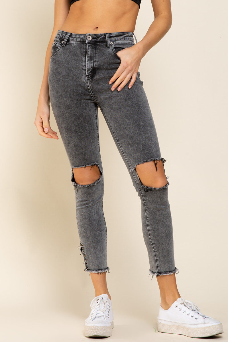 a woman in black top and ripped jeans
