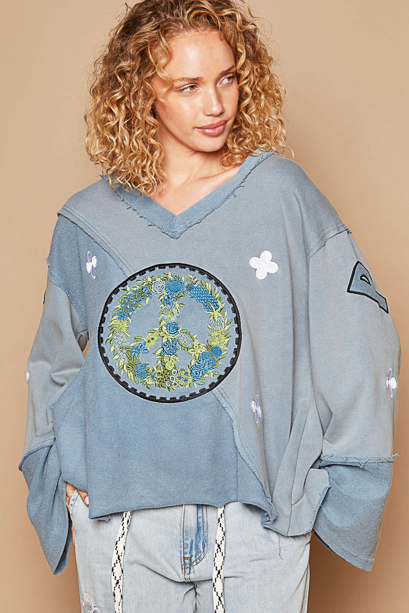 a woman with curly hair wearing a blue sweatshirt