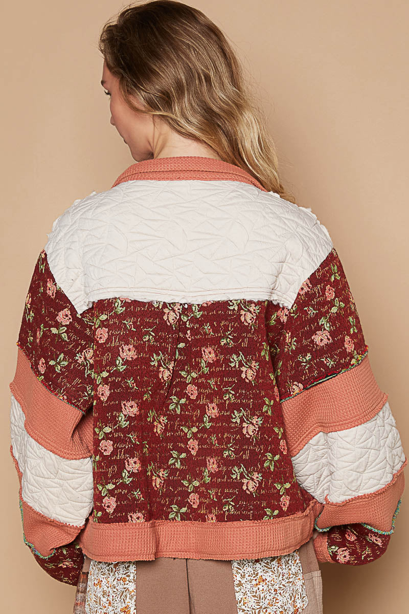 a woman wearing a jacket with flowers on it
