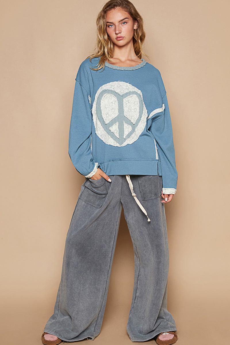 a woman wearing a peace sign sweatshirt and pants