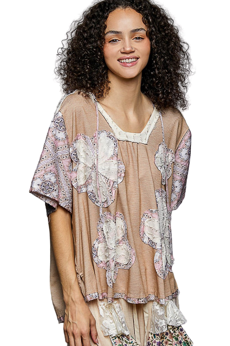 Woman wearing a beige floral blouse with a plain background
