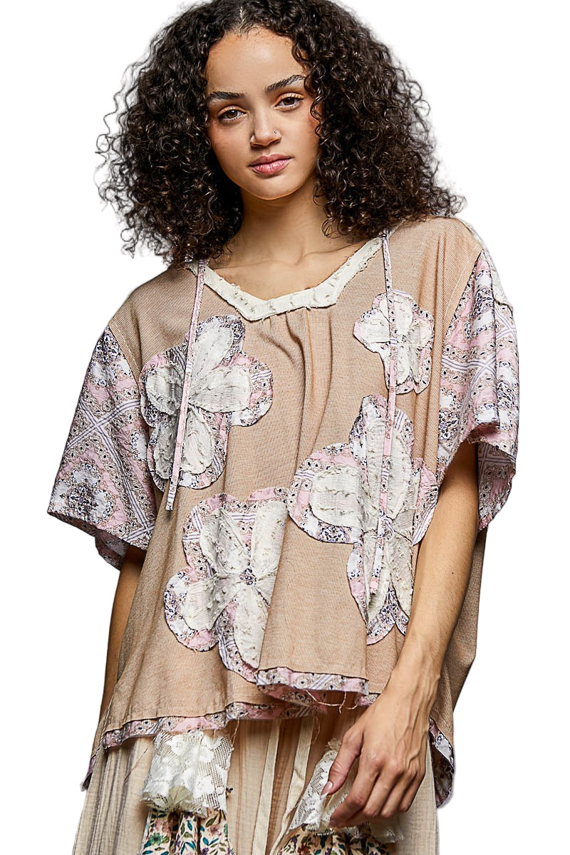 Woman wearing a beige and floral patterned outfit on a gray background
