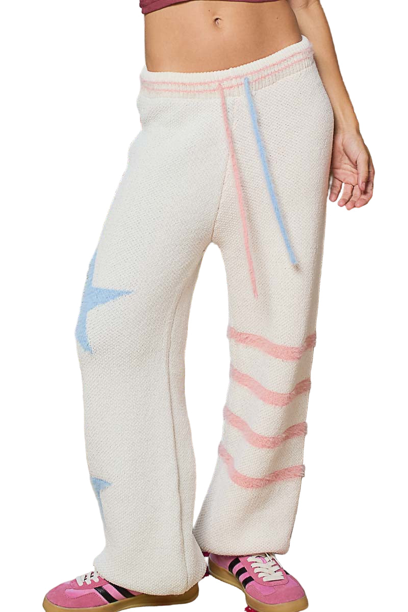 Person wearing white pants with colorful stripes, standing outdoors.