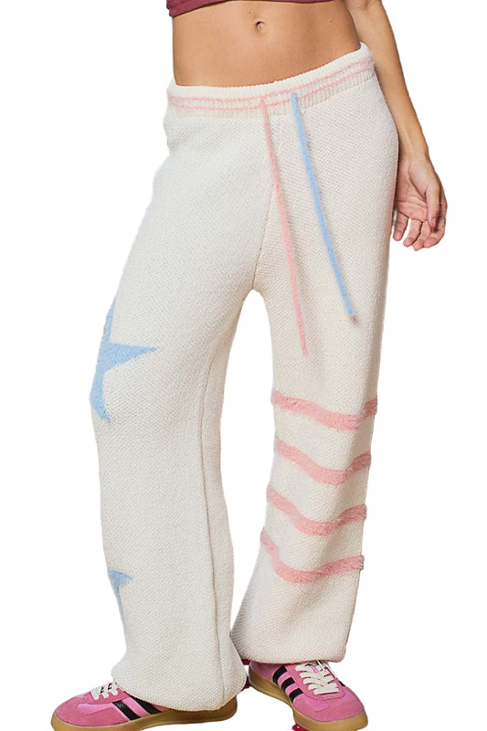 Person wearing white pants with colorful stripes, standing outdoors.