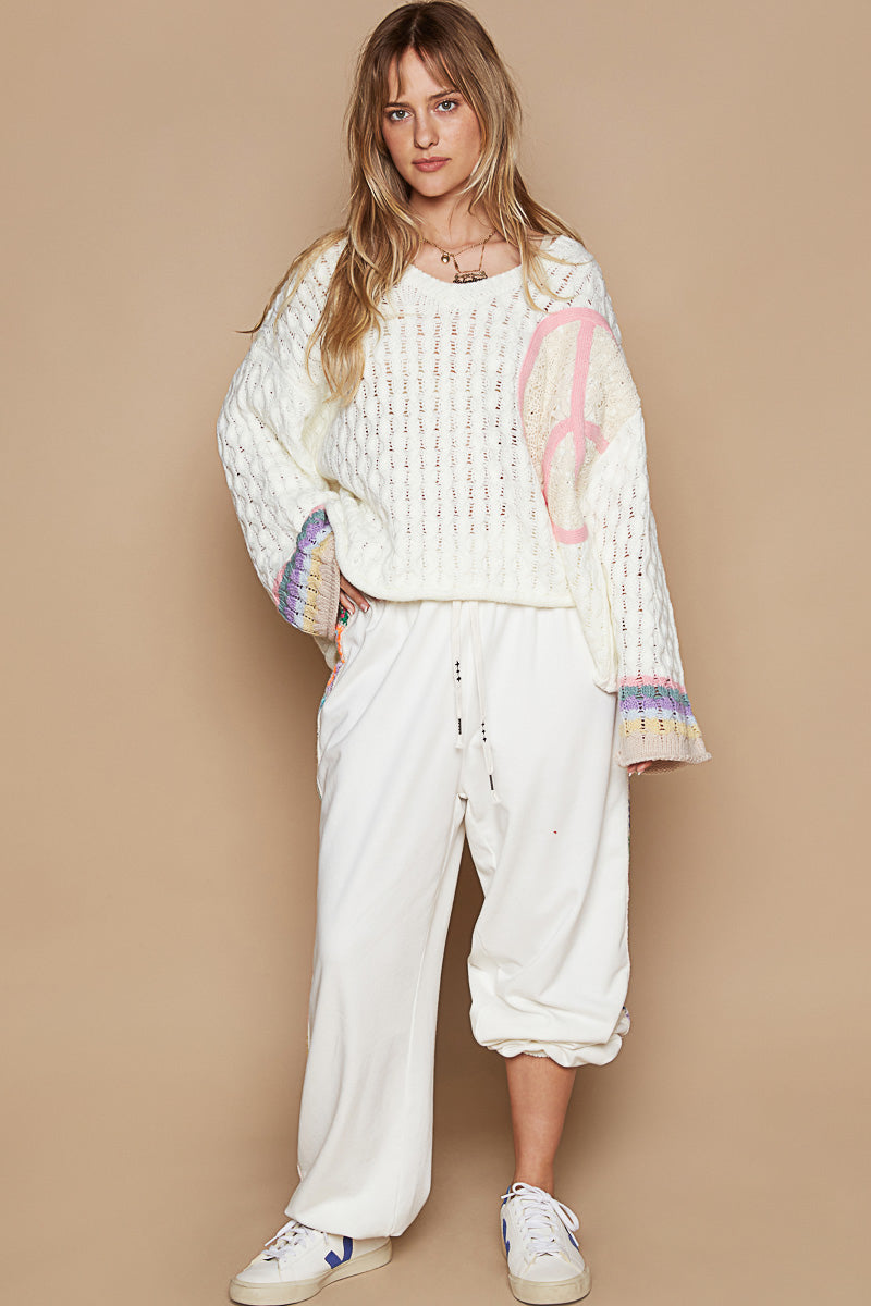 a woman in a white sweater and white pants