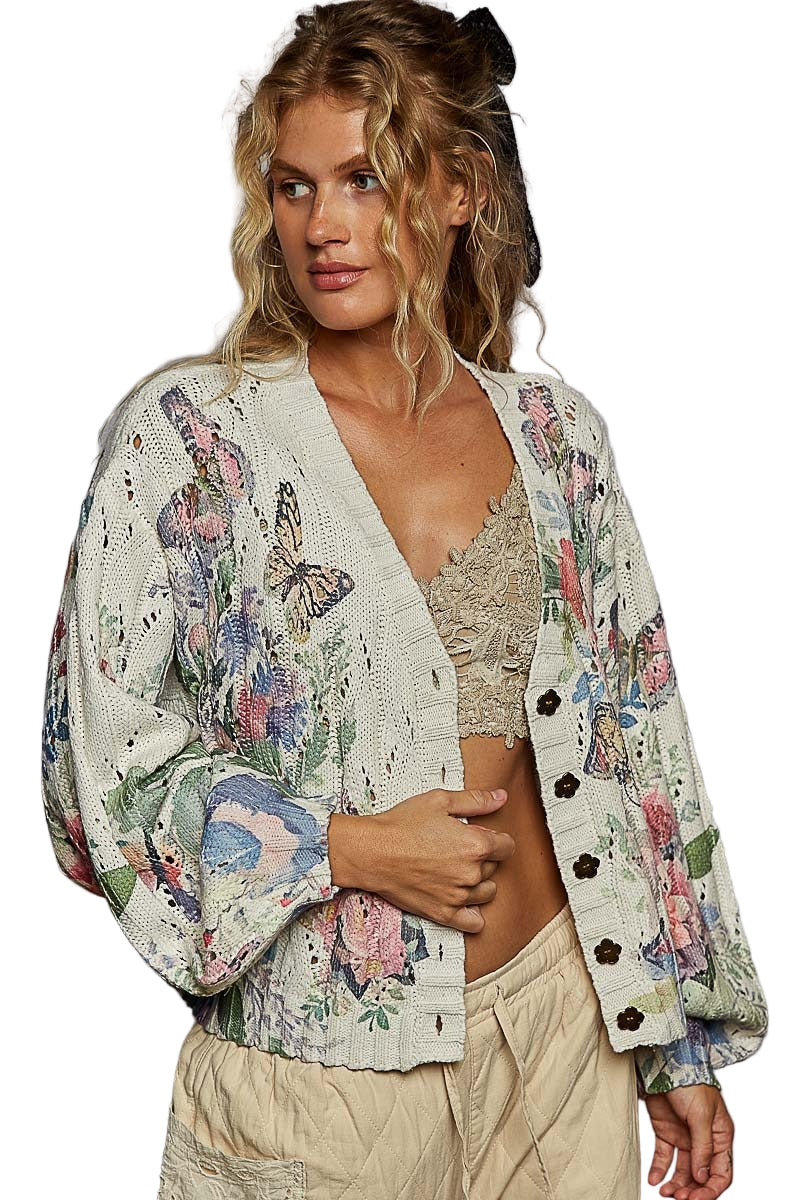 Woman wearing a floral cardigan with butterfly designs on a white background