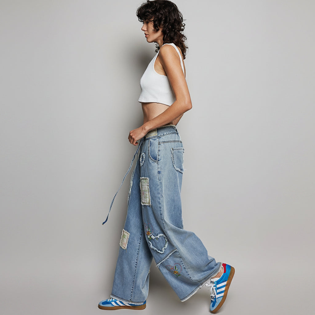 POL Clothing women's light blue wide-leg patchwork denim pants with frayed patches, side walking view
