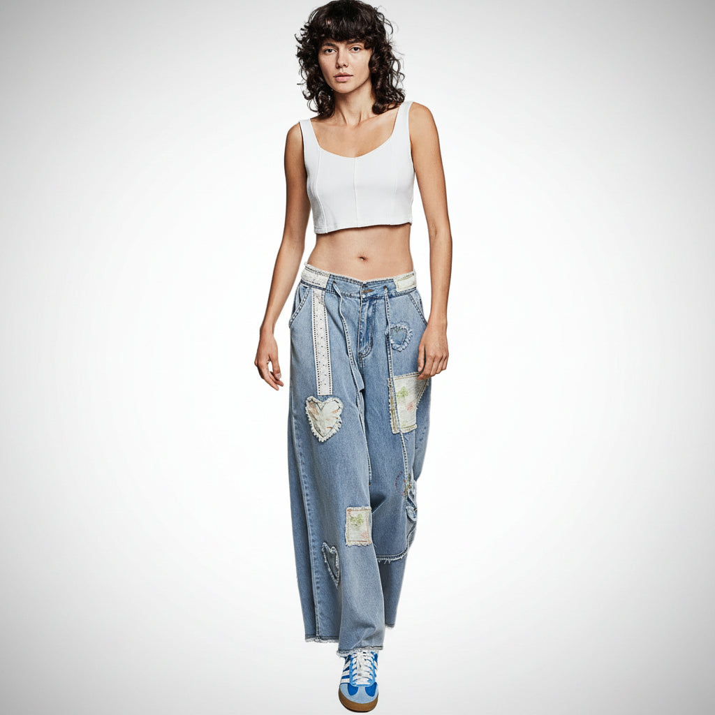 POL Clothing women's light blue wide-leg patchwork denim pants with heart appliqués and floral embroidery, front view
