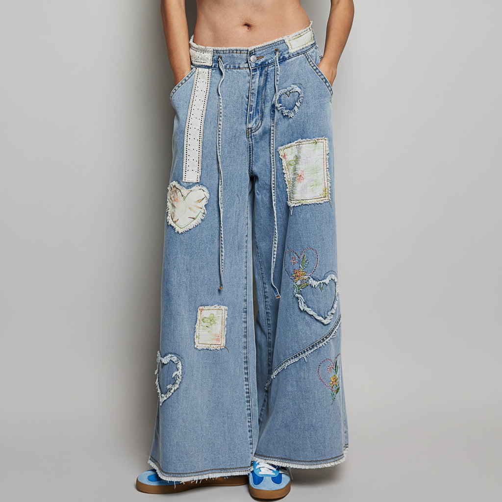 POL Clothing women's patchwork denim pants detail showing lace eyelet waistband, heart appliqués, and rhinestone trim
